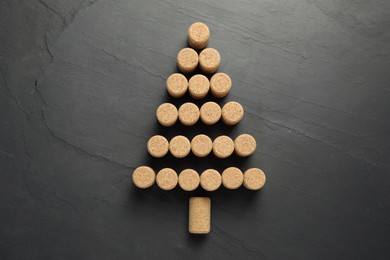 Photo of Christmas tree made of wine corks on dark stone background, top view