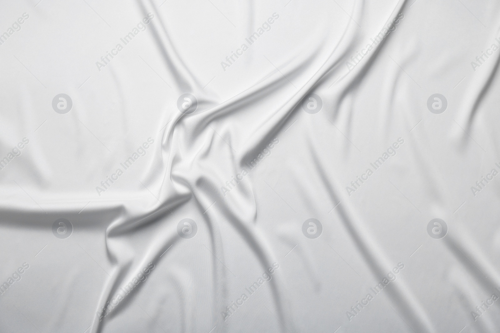 Photo of Texture of white crumpled silk fabric as background, top view