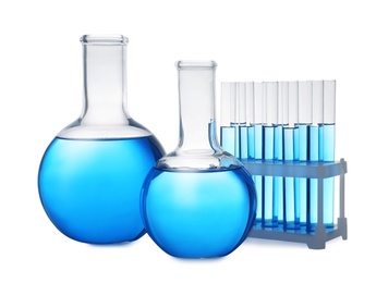 Photo of Set of laboratory glassware with blue liquid on white background