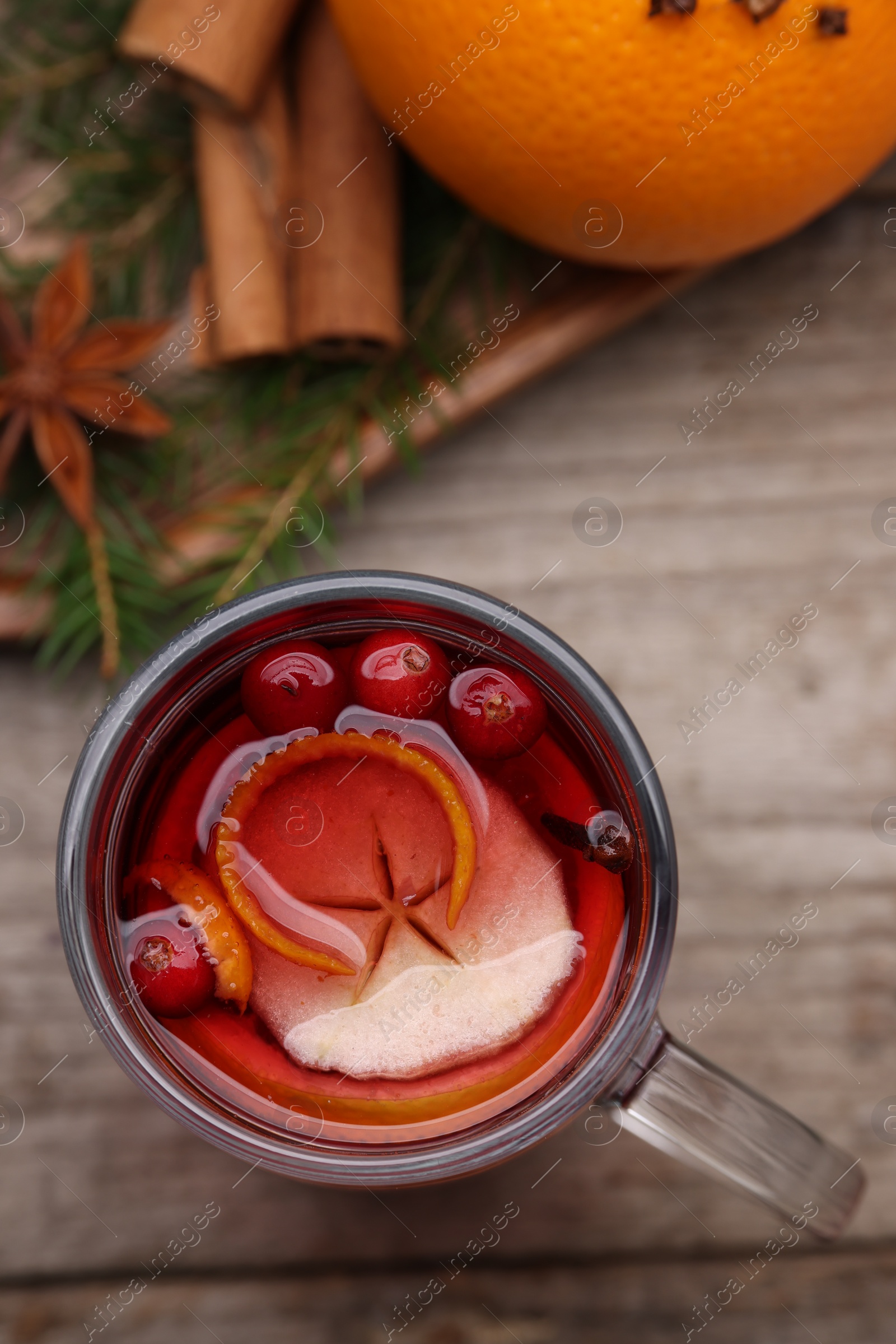 Photo of Aromatic mulled wine in glass cup on table, top view