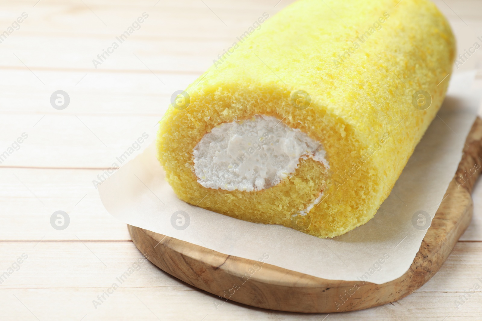 Photo of Delicious cake roll on light wooden table, closeup