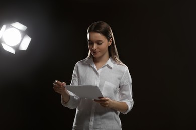 Professional actress reading her script during rehearsal in theatre