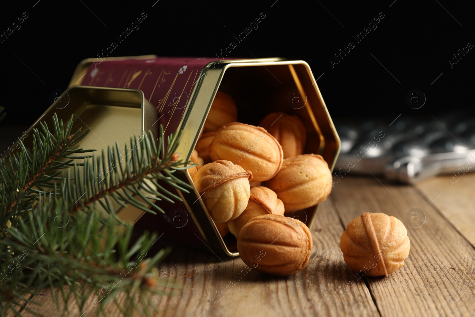 Photo of Homemade walnut shaped cookies with boiled condensed milk and fir branches on wooden table