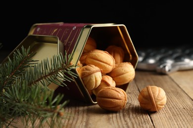 Photo of Homemade walnut shaped cookies with boiled condensed milk and fir branches on wooden table