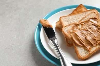 Plate with toast bread and peanut butter on table