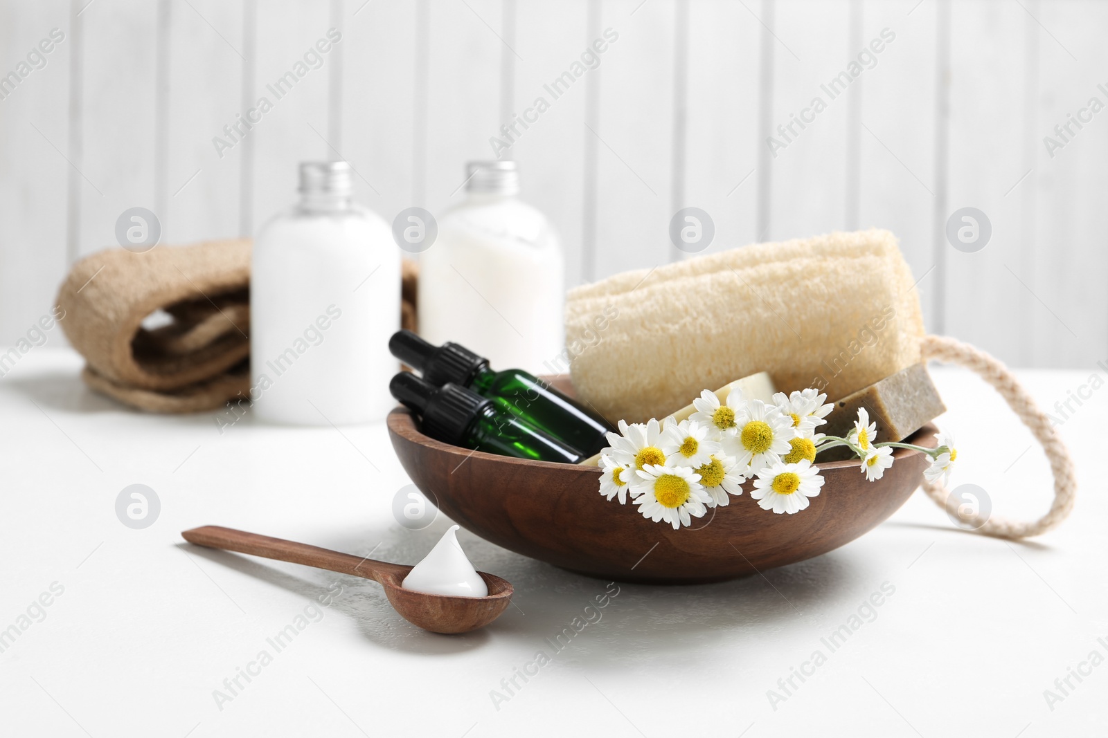 Photo of Composition with chamomile flowers and cosmetic products on white table