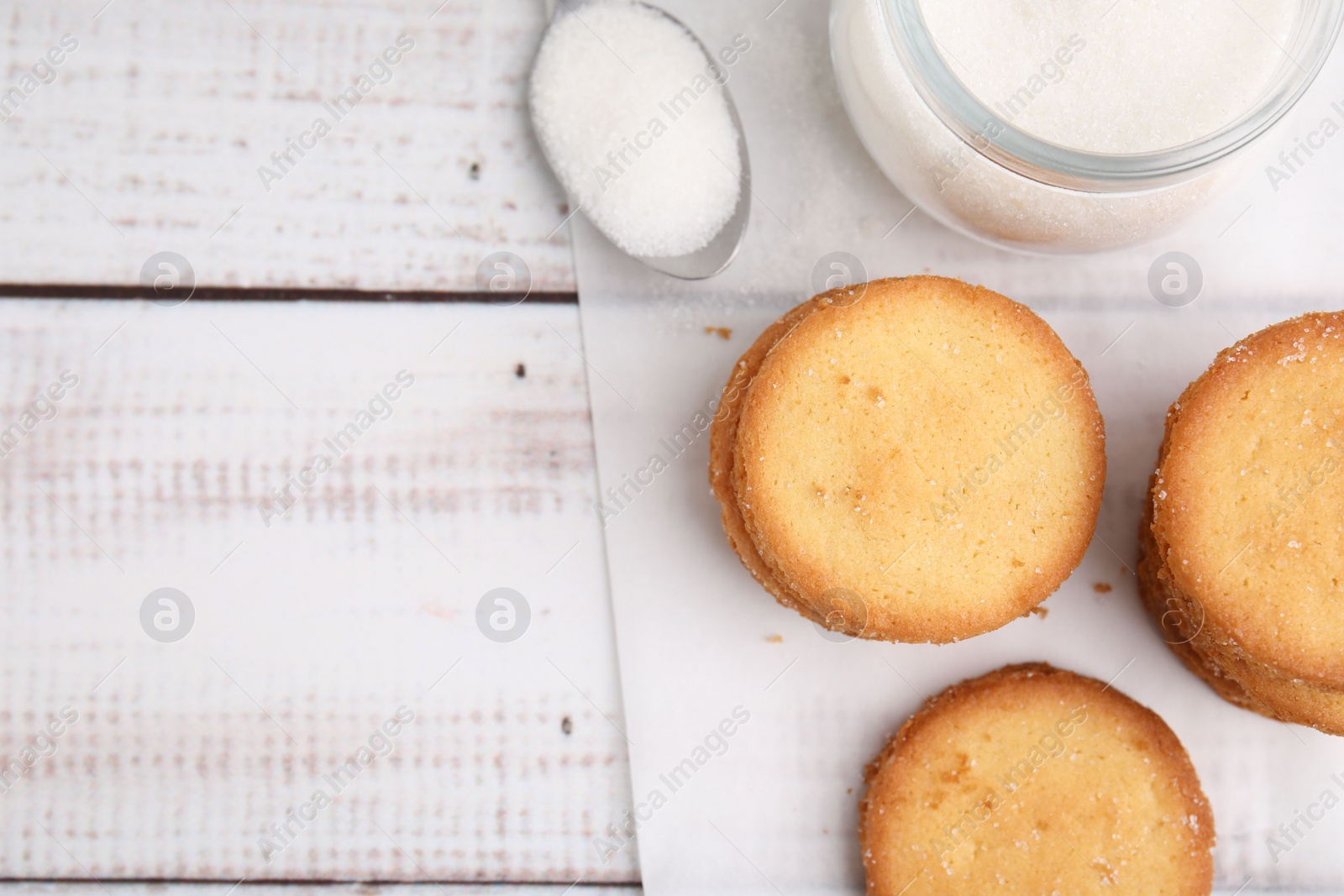 Photo of Tasty sweet sugar cookies on white wooden table, top view. Space for text