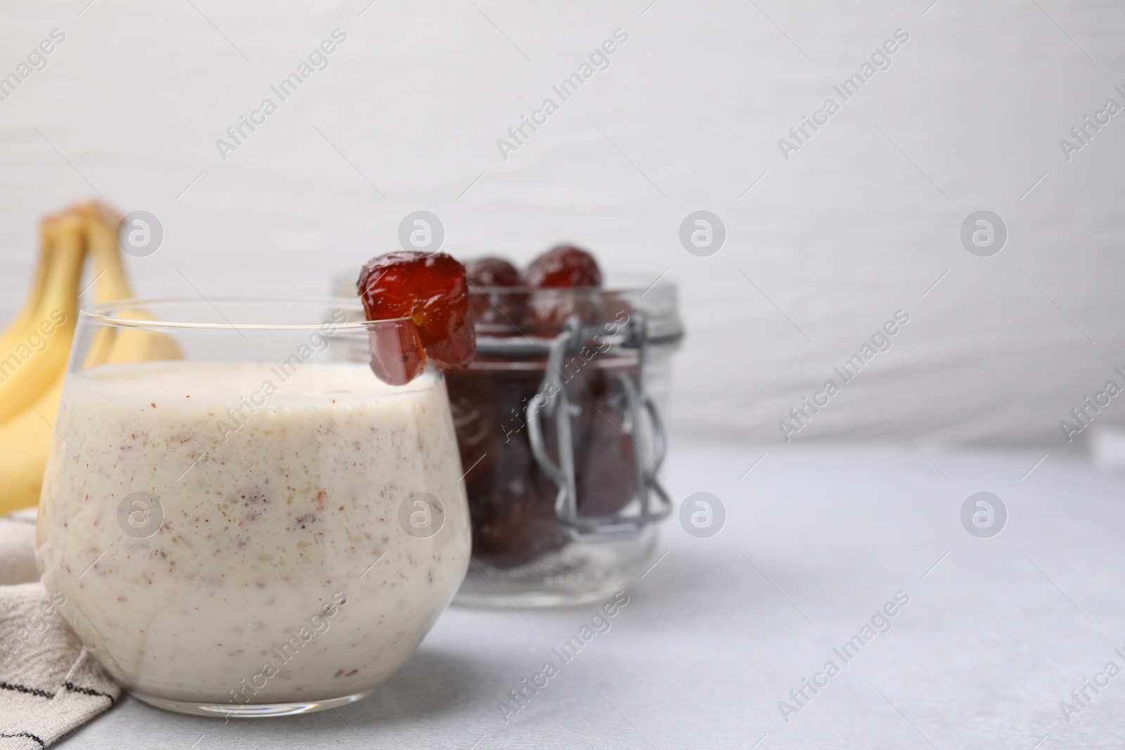Photo of Glass of delicious date smoothie on white table