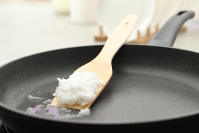 Photo of Frying pan with coconut oil on induction stove, closeup. Healthy cooking