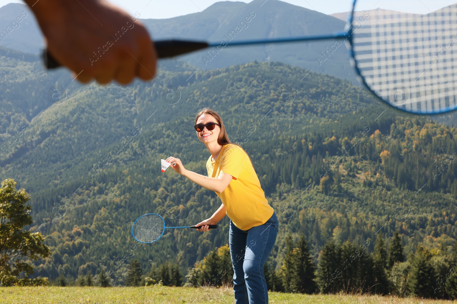 Photo of Woman playing badminton in mountains on sunny day