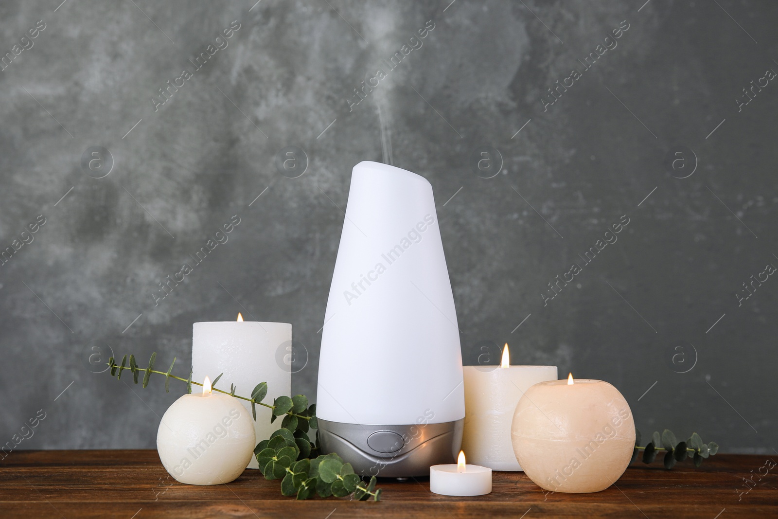 Photo of Composition with aroma humidifier on table against grey background. Space for text