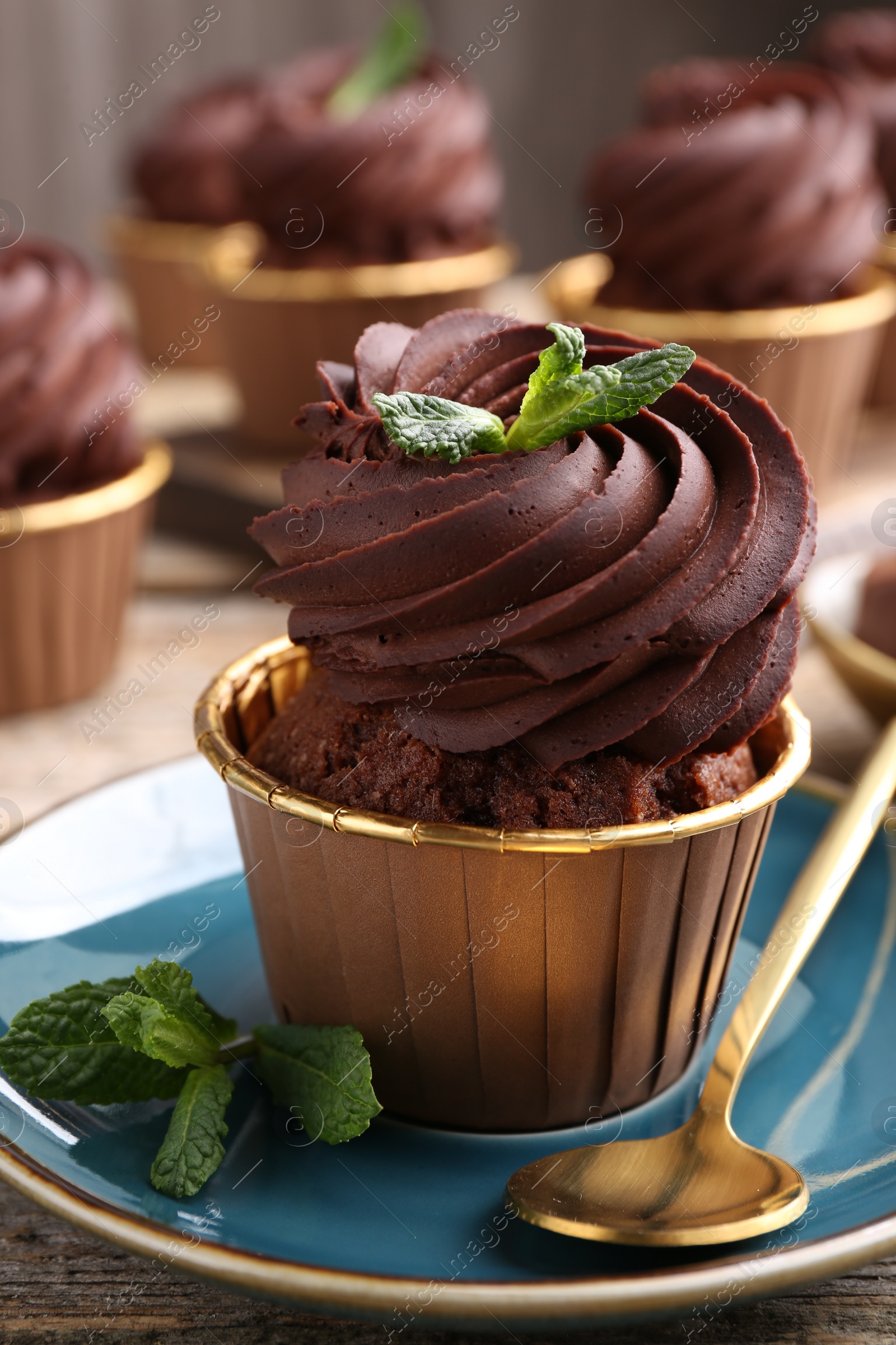 Photo of Delicious chocolate cupcake with mint on table, closeup