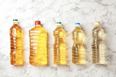 Bottles of oils on marble background, top view