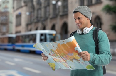 Happy traveler with map in foreign city. Vacation trip