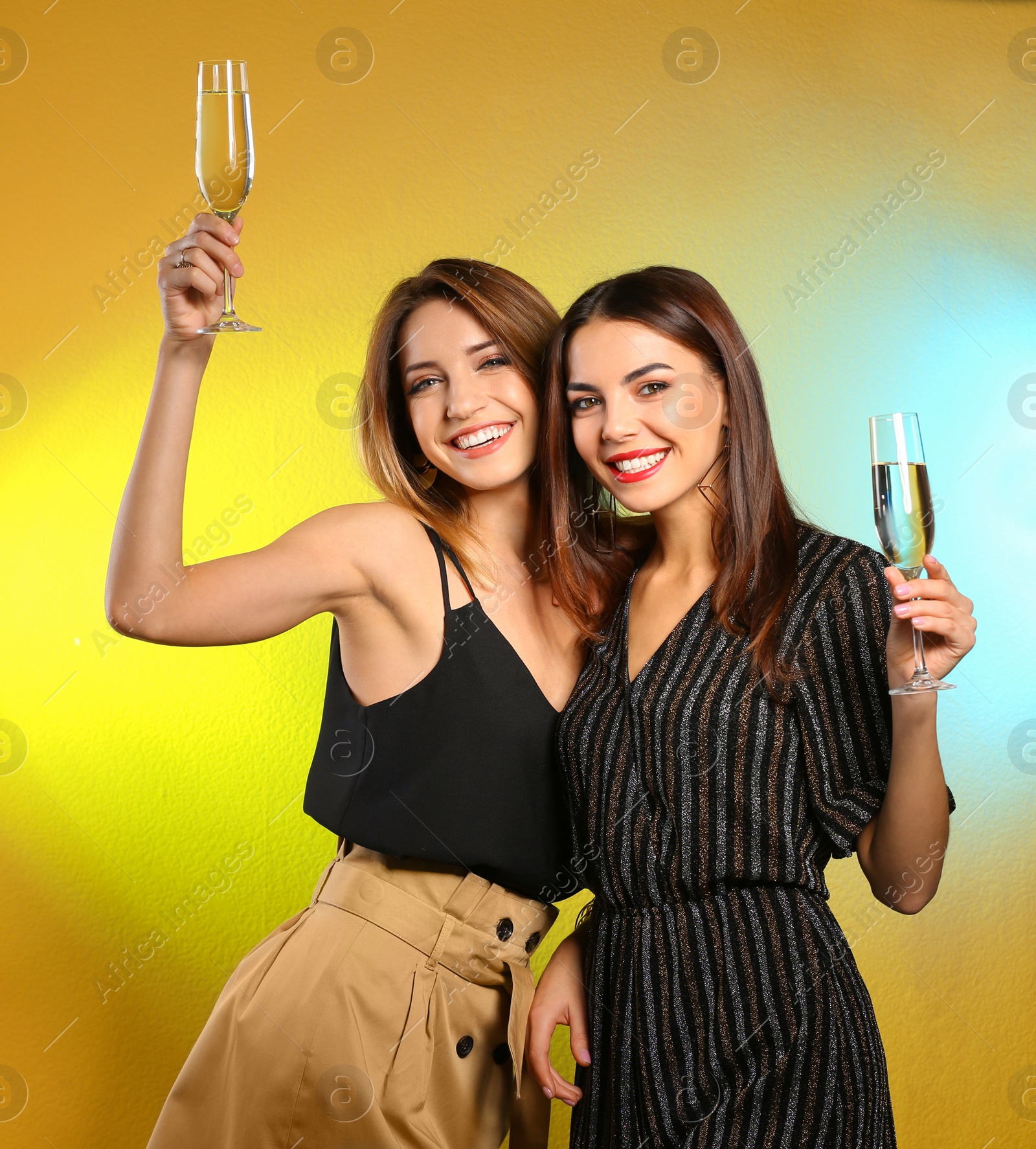 Photo of Portrait of happy friends with champagne in glasses on color background