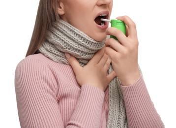 Photo of Woman using throat spray on white background, closeup
