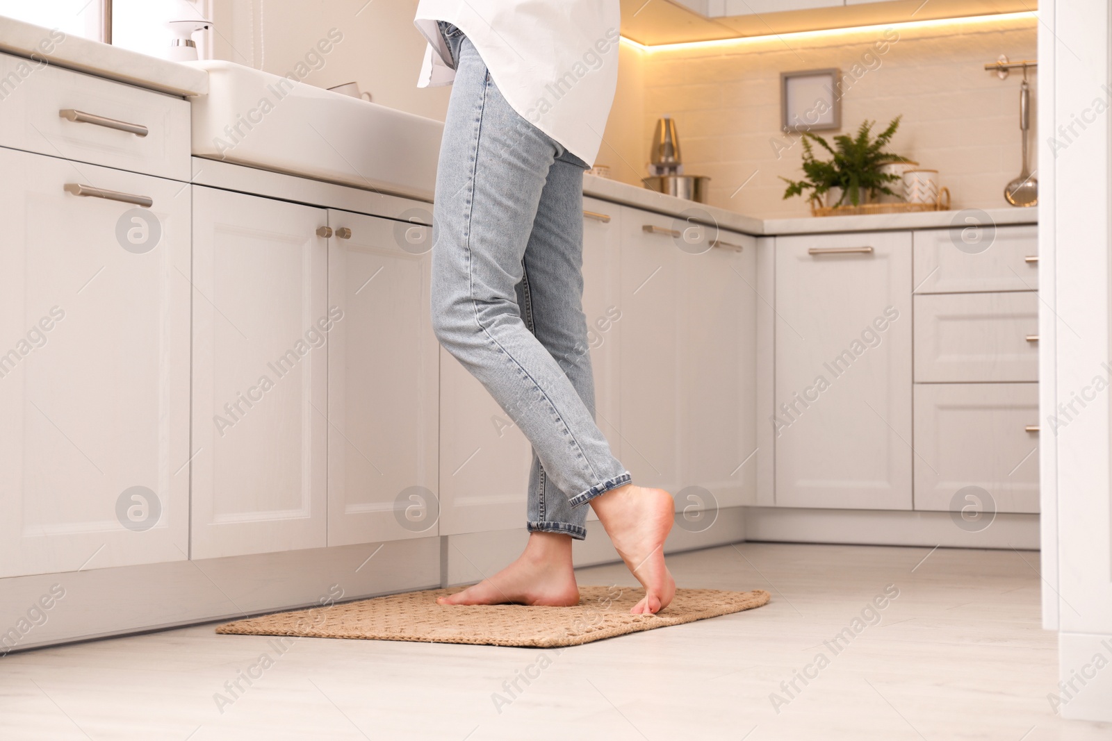 Photo of Woman standing on rug in kitchen, closeup