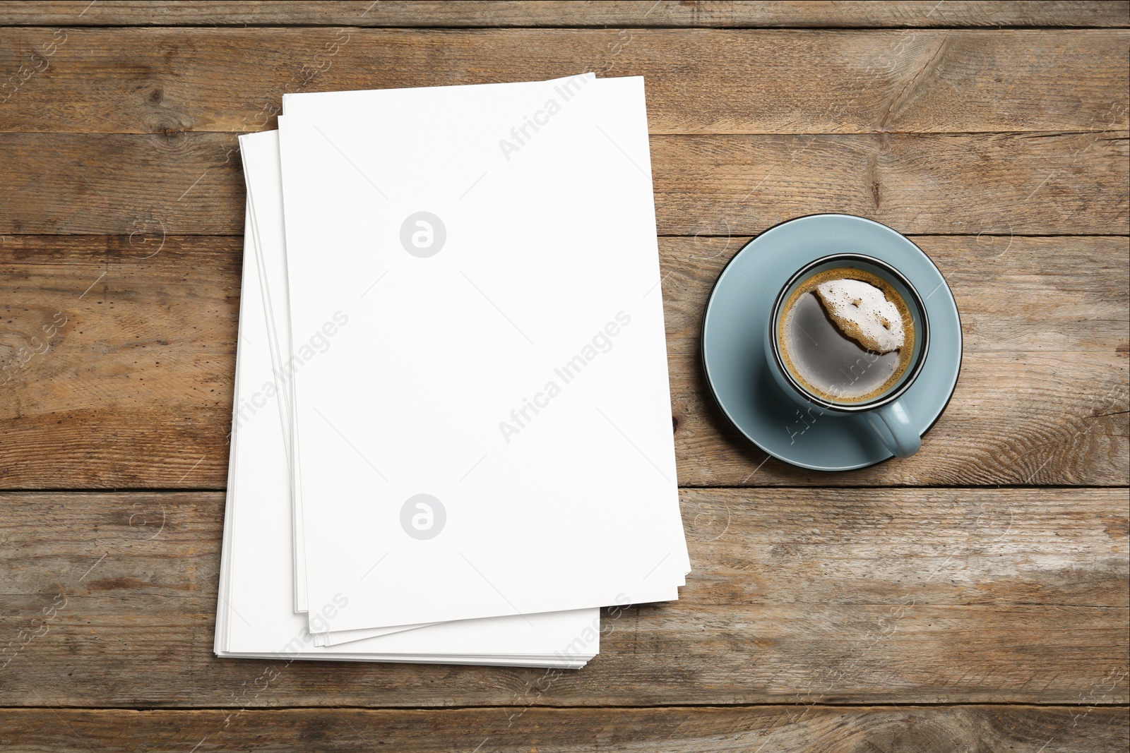 Photo of Blank paper sheets for brochure and cup of coffee on wooden background, flat lay. Mock up