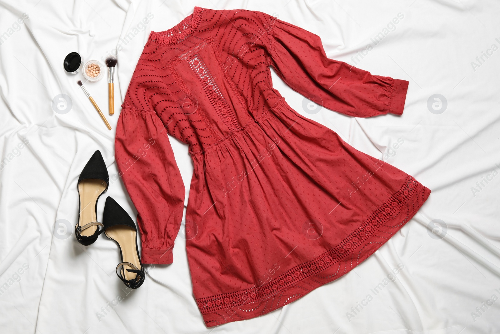 Photo of Flat lay composition with stylish red dress on white fabric