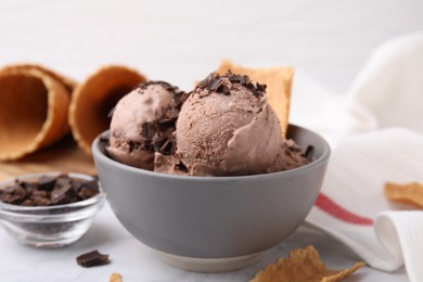 Photo of Bowl of tasty ice cream with chocolate chunks on table, closeup