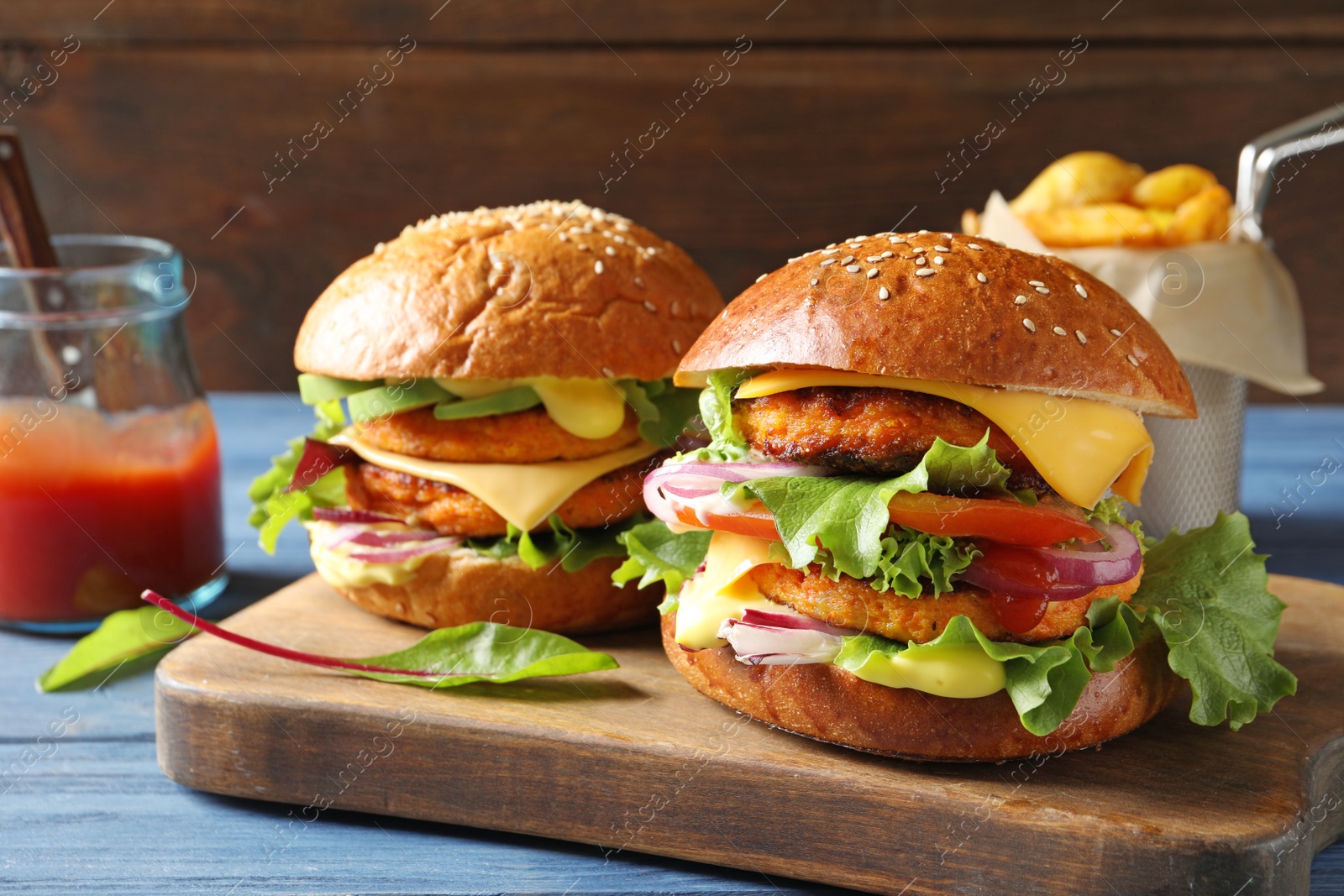 Photo of Wooden board with double vegetarian burgers on table