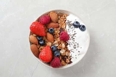 Photo of Tasty homemade granola served on marble table, top view. Healthy breakfast