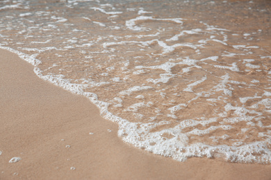 Beautiful sea waves on sandy beach, closeup
