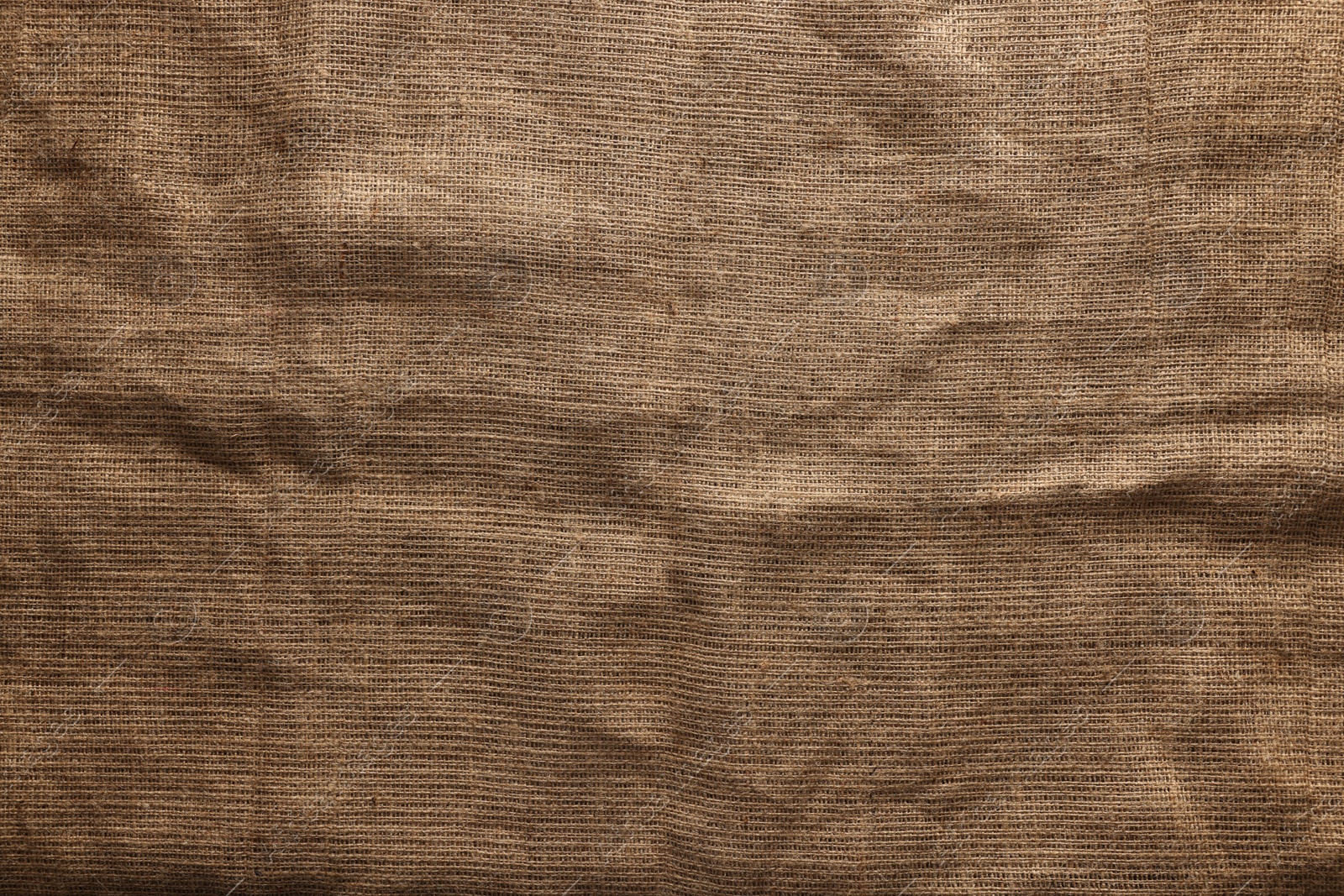 Photo of Texture of natural burlap fabric as background, top view