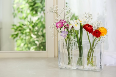 Photo of Beautiful fresh flowers on window sill indoors. Space for text