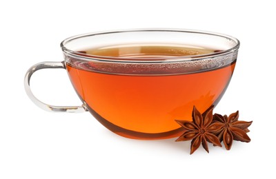 Photo of Glass cup of hot tea with anise stars on white background