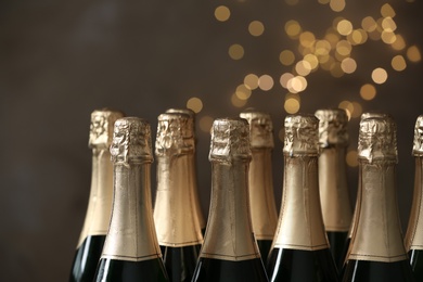 Photo of Many bottles of champagne on blurred background, closeup