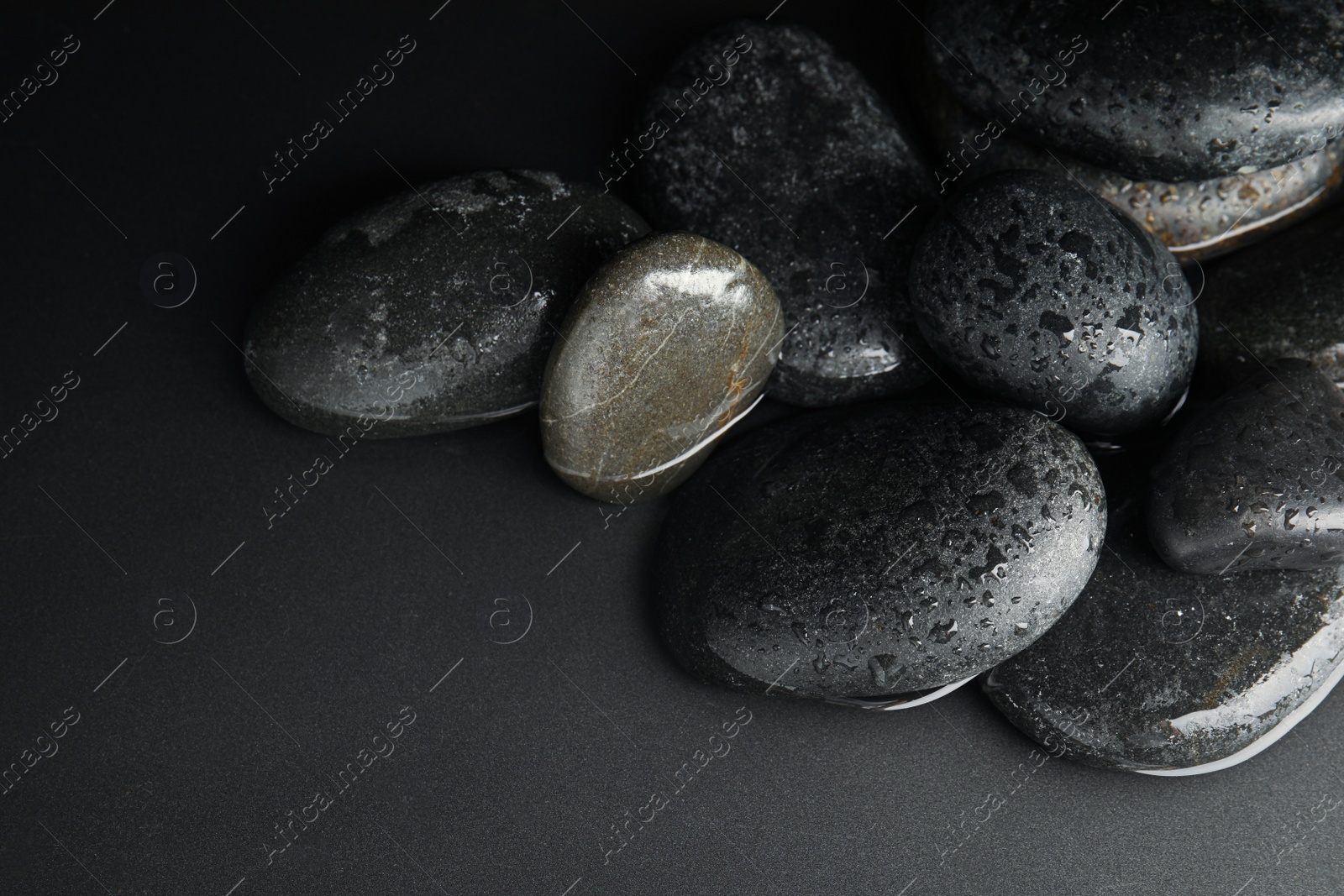 Photo of Stones in water on black background. Zen lifestyle