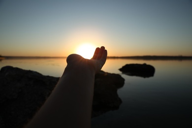 Photo of Woman reaching for sun outdoors, closeup. Healing concept