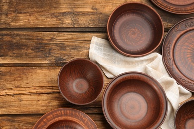 Set of clay utensils on wooden table, flat lay