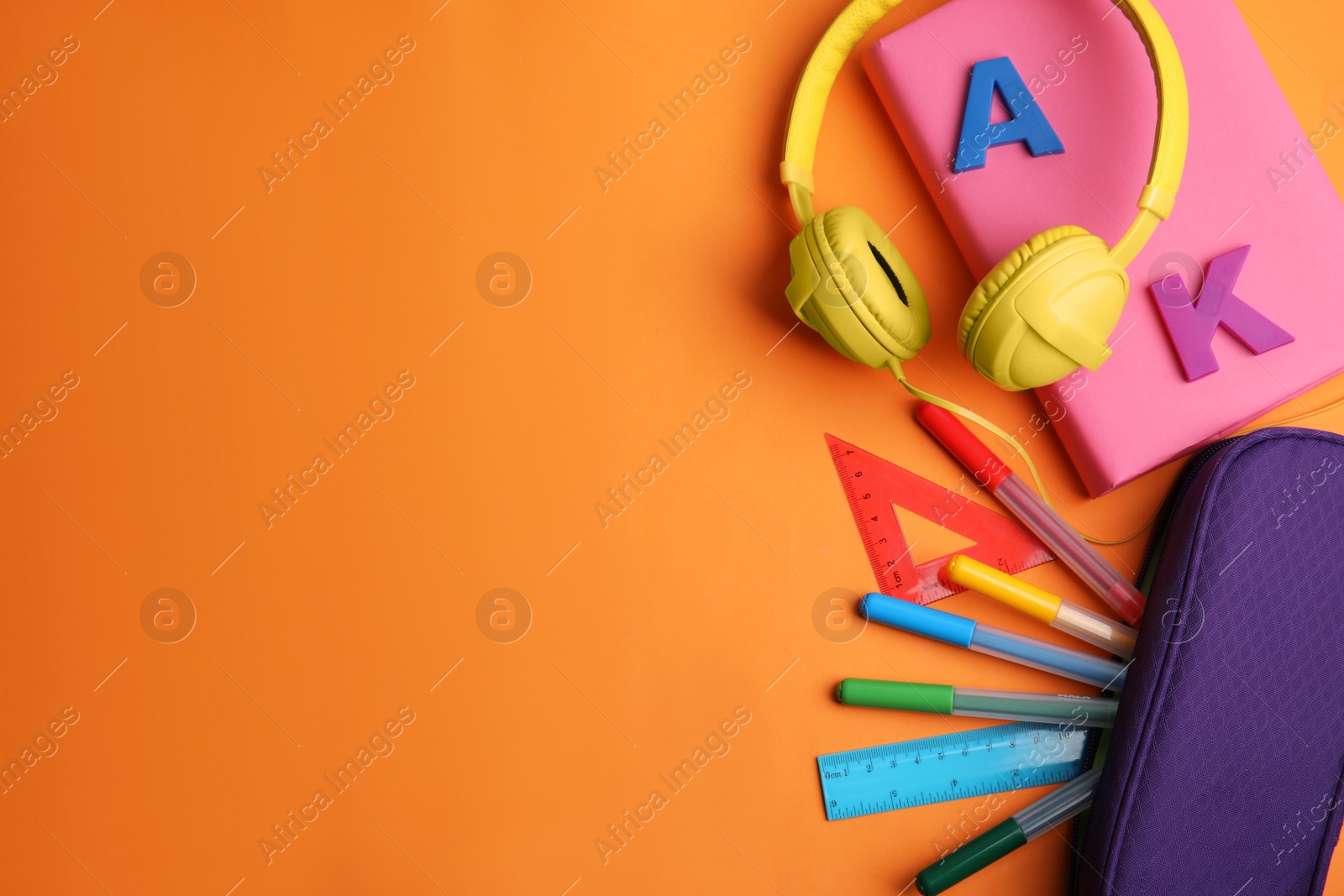 Photo of Flat lay composition with book and stationery on orange background. Space for text