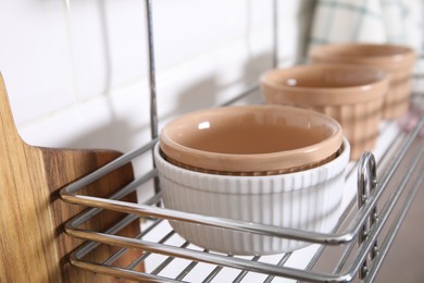 Photo of Many different ramekins on metal rack in kitchen, closeup