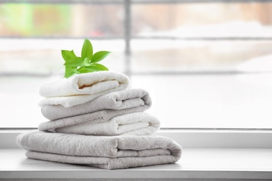 Stack of clean towels on window sill