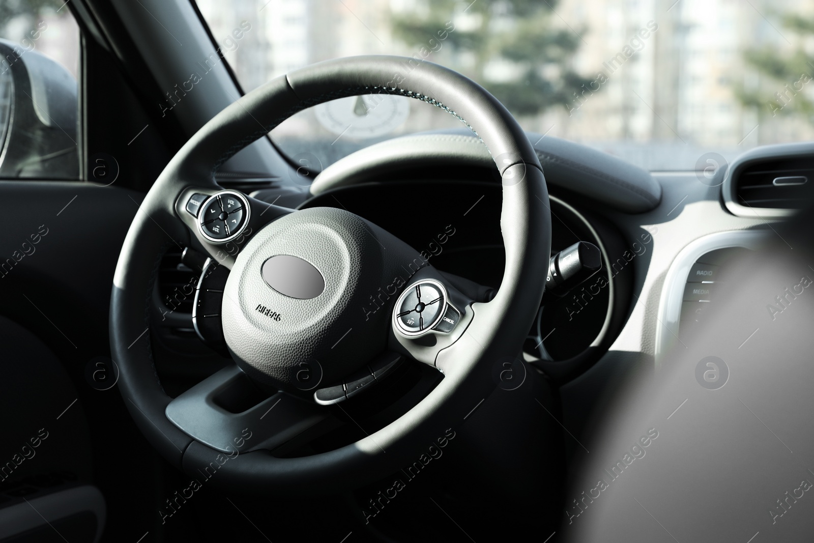 Photo of Black steering wheel and dashboard in modern car