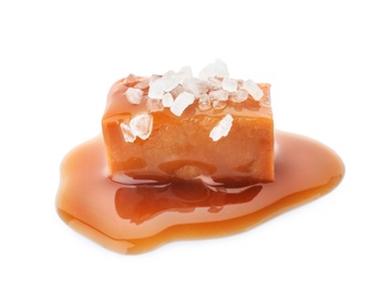 Photo of Delicious candy with caramel sauce and salt on white background
