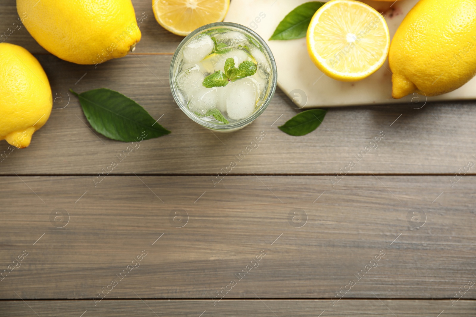 Photo of Cool freshly made lemonade and fruits on wooden table, flat lay. Space for text