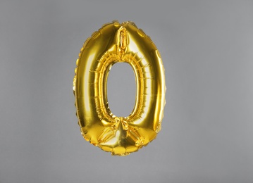 Golden number zero balloon on grey background