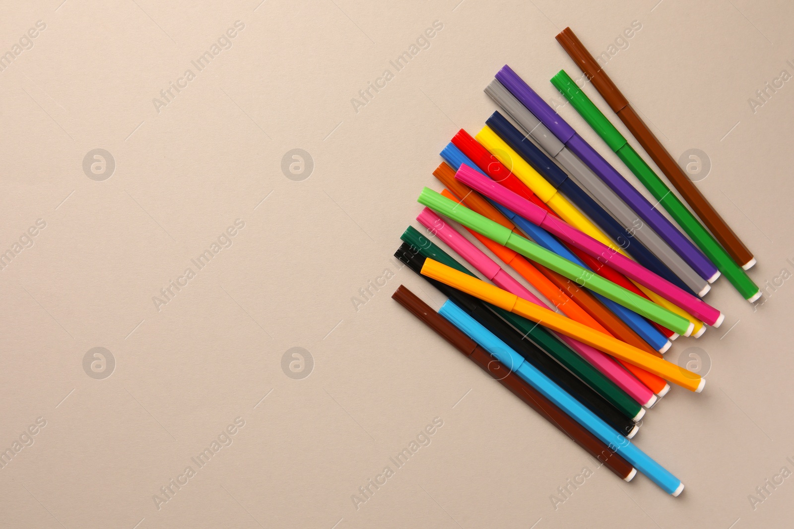 Photo of Many bright markers on light grey background, flat lay. Space for text