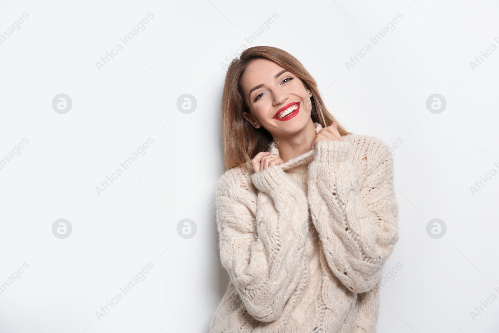 Photo of Beautiful young woman in warm sweater on white background. Space for text
