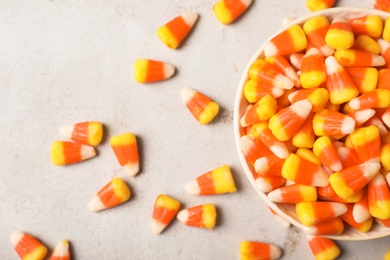 Flat lay composition with bowl of delicious candy corns on gray background
