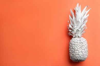 White pineapple on orange background, top view with space for text. Creative concept