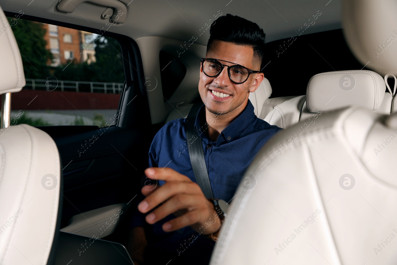 Photo of Businessman sitting on backseat of modern taxi