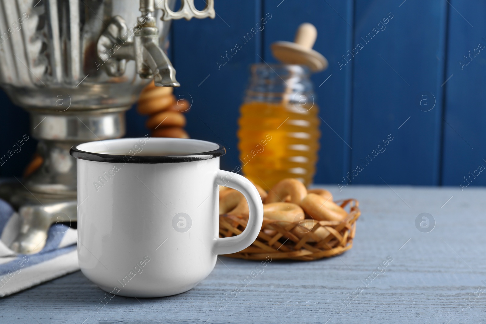 Photo of Delicious ring shaped Sushki (dry bagels), focus on mug of tea and samovar. Space for text