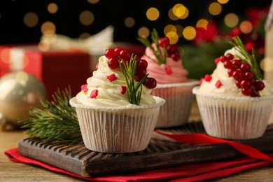 Photo of Delicious cupcakes and Christmas decorations on wooden table