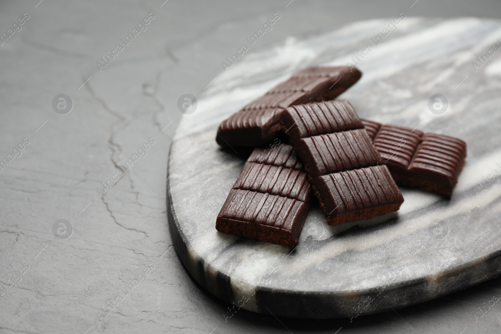 Photo of Marble board with delicious and healthy hematogen on black table. Space for text