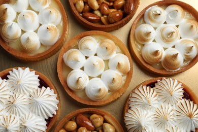 Photo of Many different tartlets on golden tray, top view. Delicious dessert